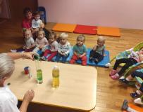 Dzieci obserwujące eksperyment wykonywany przez panią opiekunkę