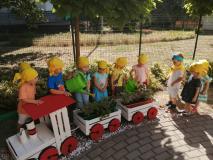 Dzieci podlewające rośliny w skrzynkach ustawionych w formie pociągu