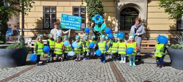 Grupa dzieci wraz z opiekunkami przed budynkiem Ratusza